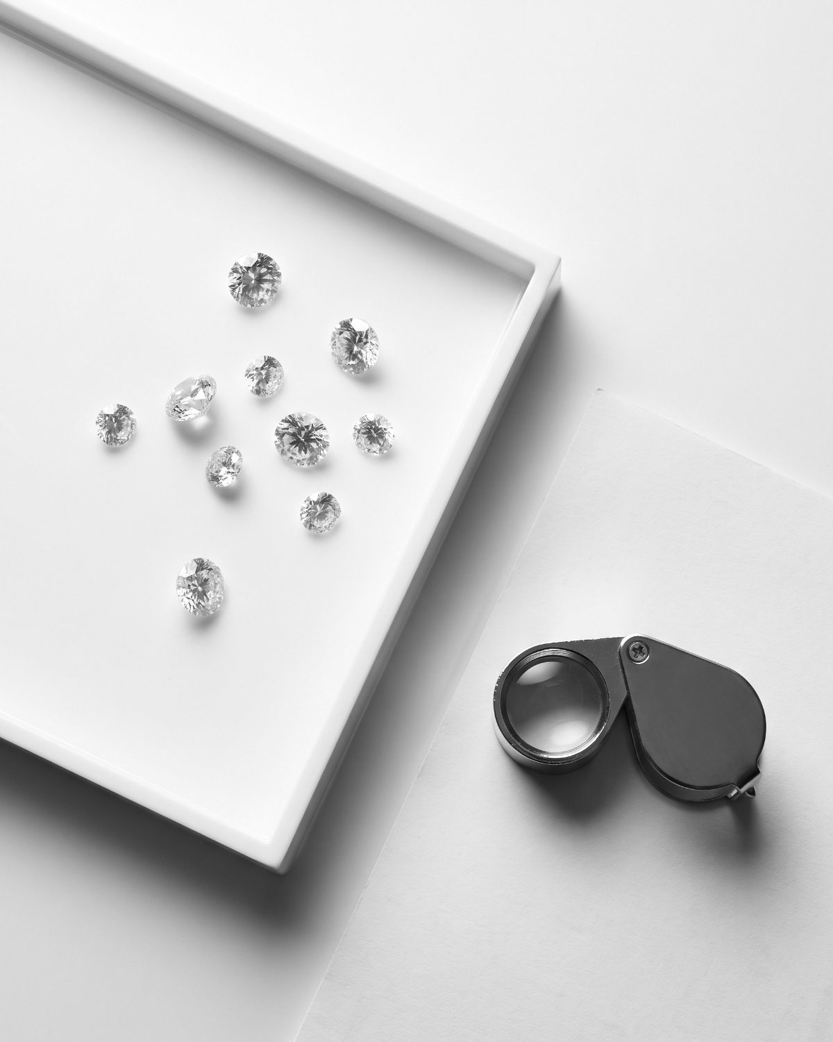 Diamonds on a grading tray with a loupe
