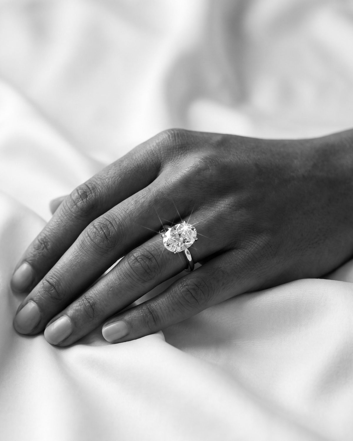 Oval diamond solitaire engagement ring on a hand