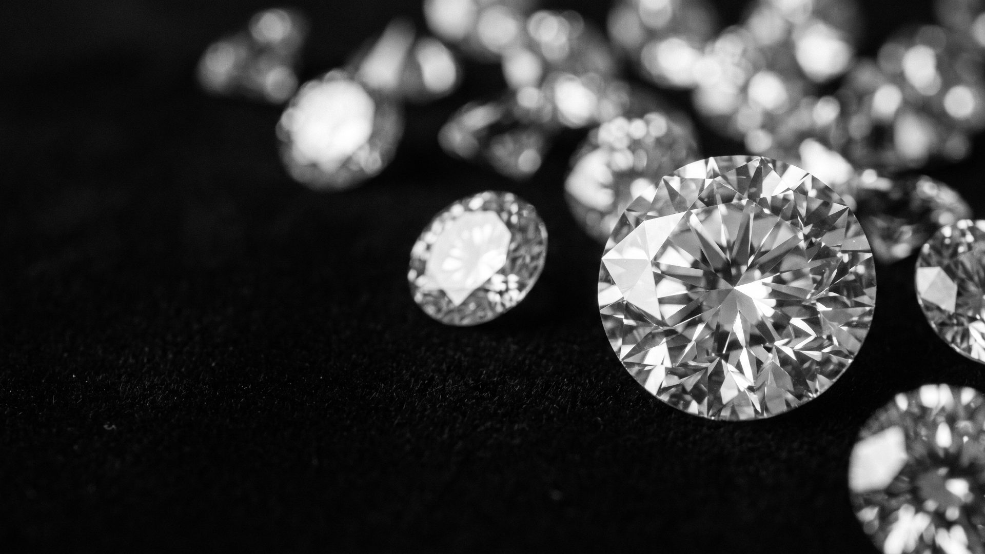 Loose round brilliant and oval diamonds on dark velvet